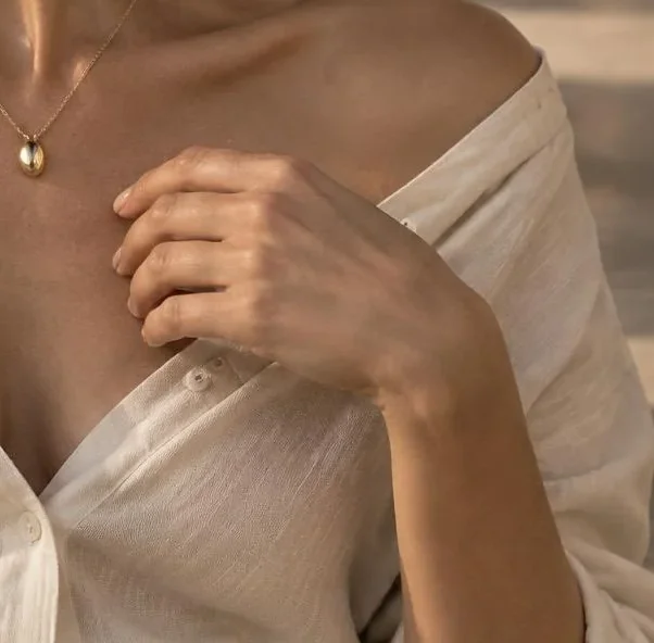 Hands and ivory fabric in directional sunlight