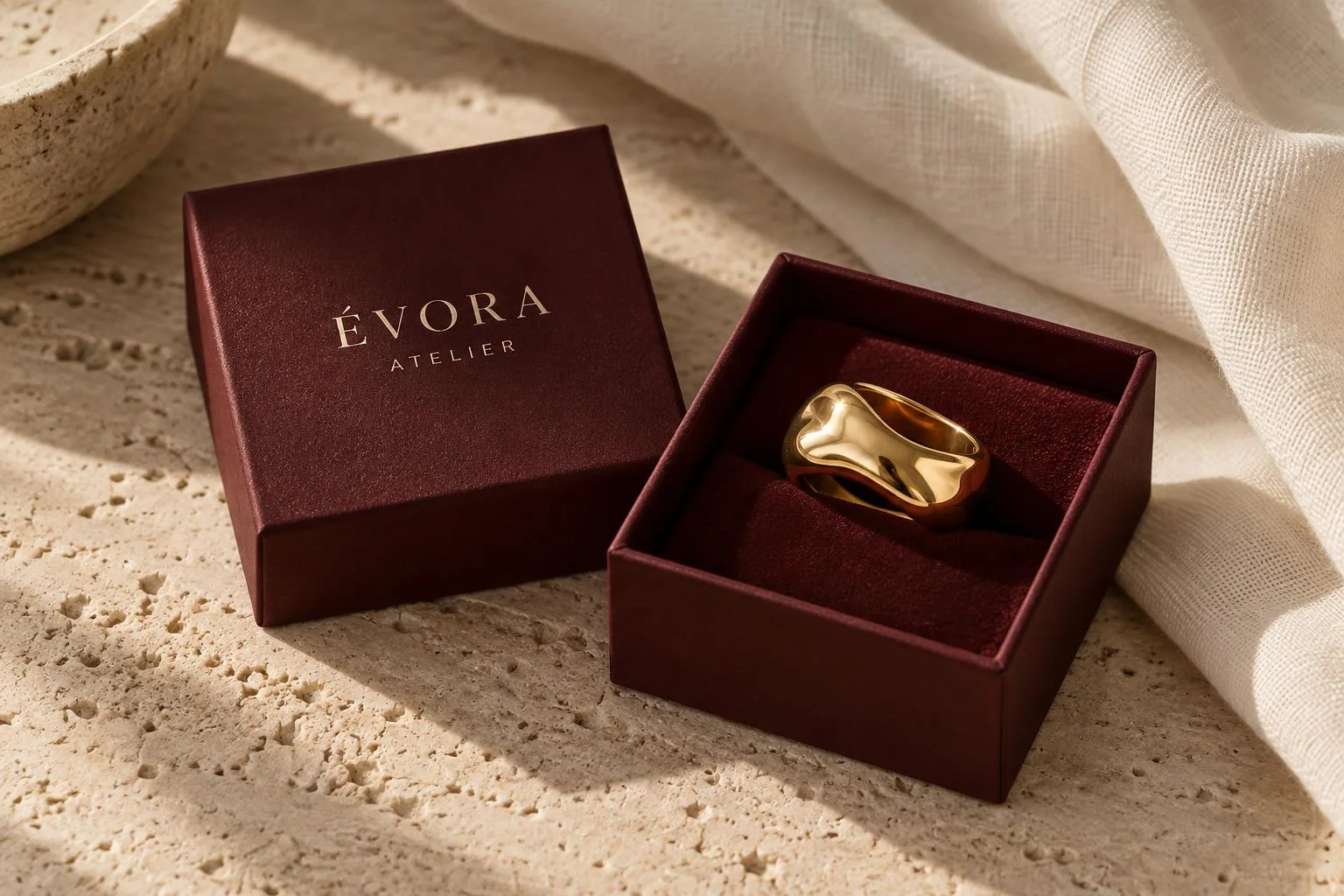 ÉVORA burgundy jewelry packaging on linen and travertine